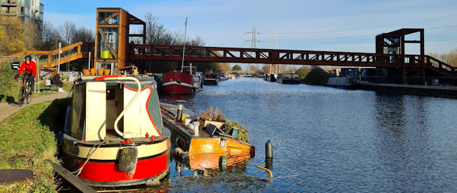 boats in a river with a bridge over it