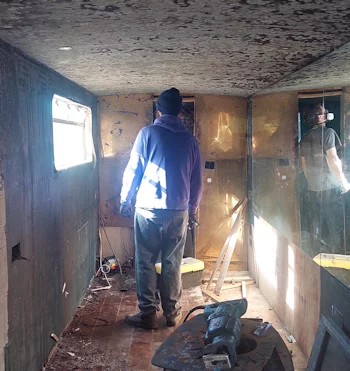 a man standing in a room with a man in a helmet
